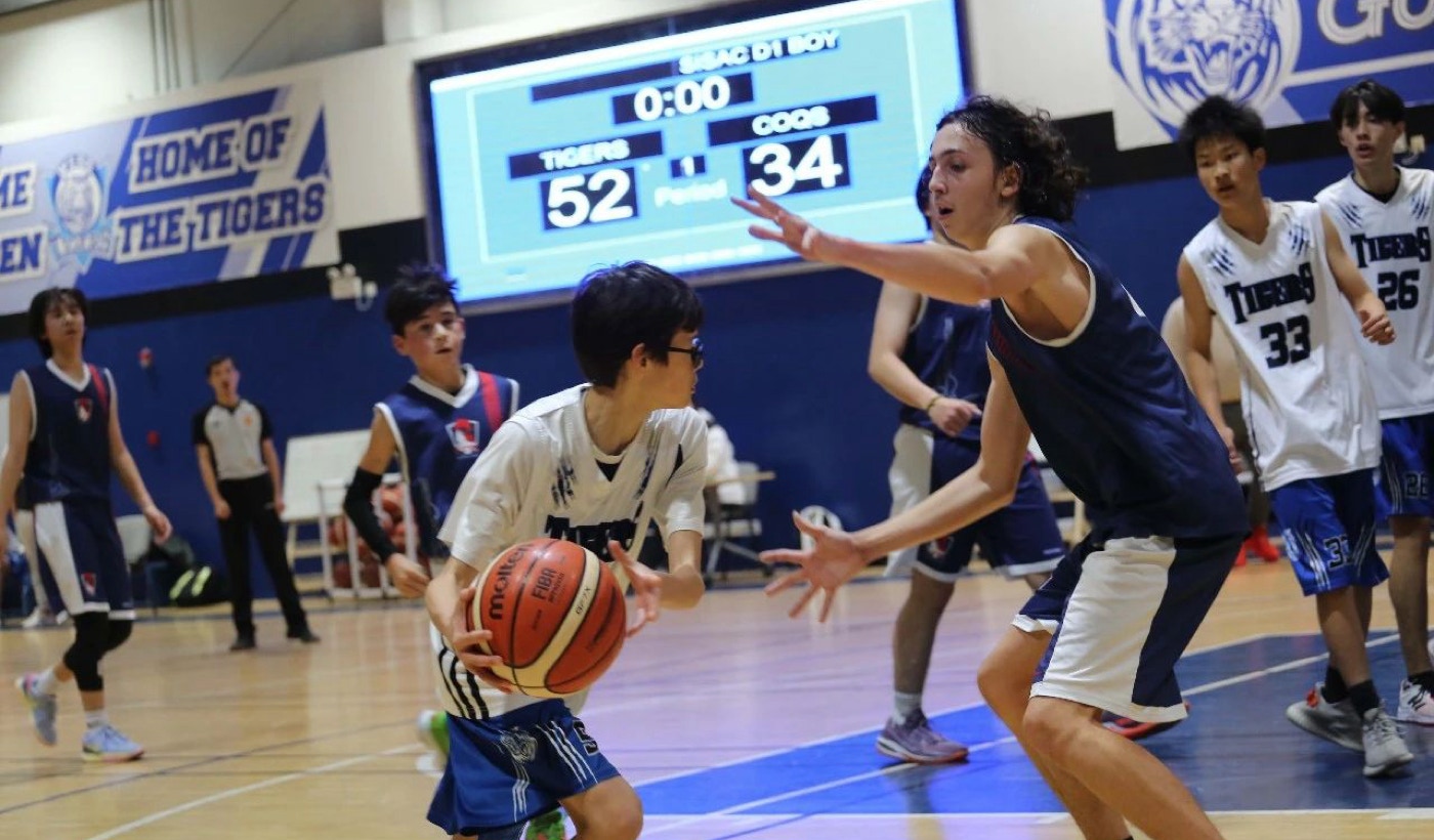 The Western International School of Shanghai (WISS Tigers) recently sparred with the Shanghai French School (LFS Coqs) in an exhilarating high school boys' basketball game. The Tigers emerged triumphant with a final score of 52 to 34, demonstrating their unwavering determination and skill on the court.  From the opening tip-off, it was evident that the LFS Coqs were a formidable opponent. Their tenacity and competitive spirit challenged the Tigers at every turn, forcing them to bring their A-game. The Coqs showcased exceptional ball-handling skills, precision shooting, and effective defensive strategies to keep the Tigers on their toes. They displayed great teamwork and coordination, executing plays with precision and determination.